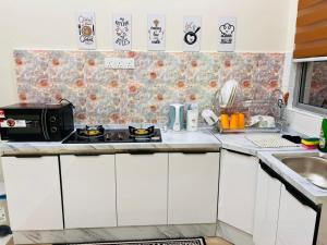 a small kitchen with a sink and a microwave at Elora Homestay in Tampin