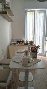 a white kitchen with a table with chairs and a counter at Amati Bed & Breakfast in Lecce