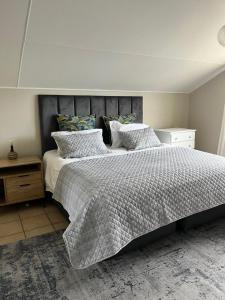 a bedroom with a large bed with white sheets and pillows at River & Salt at Stilbaai in Stilbaai-Oos