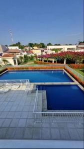 a large swimming pool with benches around it at AP da Vicky 2 quartos central São Luis in São Luís +4 photos