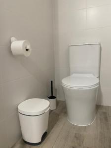 a white bathroom with a toilet and a roll of toilet paper at Jandia Arena Habitación con baño - aire acondicionado in Morro del Jable +5 photos