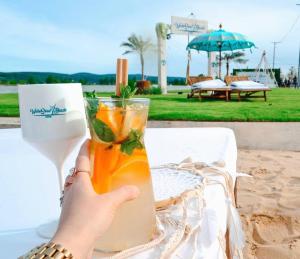 a person holding up a drink on a table at Grand Hotel Residence Pieštany Adult only Boutique hotel Next to Wake Soul Beach in Piešťany