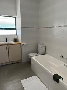a bathroom with a tub and a toilet and a sink at River & Salt at Stilbaai in Stilbaai-Oos +10 photos