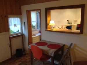 Habitación con mesa con espejo y cocina. en La Petite Maison de La Rochelle en La Rochelle
