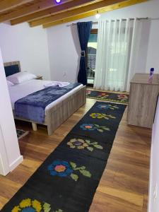 a bedroom with a bed and a black rug at Shegani House in Lin