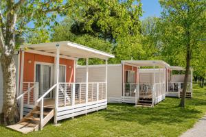 a mobile home with awning and a porch at Cesenatico Camping Village in Cesenatico