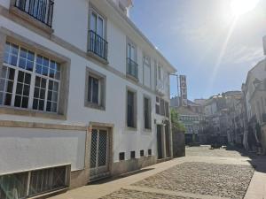 a white building on a street with the sun behind it at Hotel Vilagarcia in Vilagarcia de Arousa