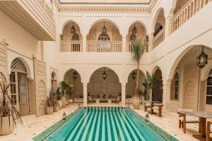 an indoor swimming pool in a building with a large house at Maison Zamane in Marrakesh