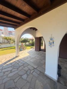 a patio with an archway in a house at Villa Nikoleta - Beach Front luxury villa with beach access in Akti Salonikiou