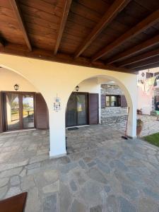 an outdoor patio with a wooden ceiling and a building at Villa Nikoleta - Beach Front luxury villa with beach access in Akti Salonikiou