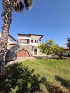 a house with a car parked in front of it at Villa Nikoleta - Beach Front luxury villa with beach access in Akti Salonikiou +30 photos