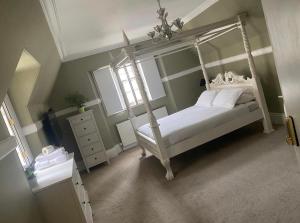 a bedroom with a white canopy bed and a window at West End Beds in Dundee
