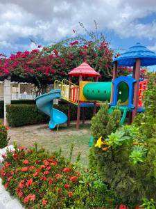 a playground with a slide in a garden with flowers at AP da Vicky 2 quartos central São Luis in São Luís