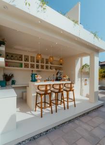 an open kitchen and dining area with a table and chairs at Salt & Palm Villa in Maggona West