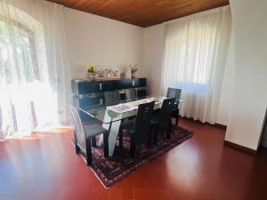 a dining room with a black table and chairs at Holiday al Poggettone in Monteroni dʼArbia