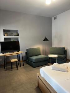 a room with a bed and a couch and a desk at Dimora Federica in Erbusco