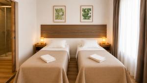 a room with two beds with towels on them at INT Lisbon Suites in Lisbon
