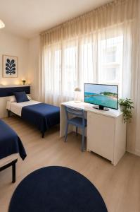 a bedroom with two beds and a desk with a computer at Appartamenti Gabicce Mare in Gabicce Mare