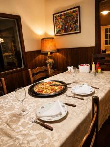 a table with a pizza on top of it at Fazenda Vista Soberba in Nova Friburgo