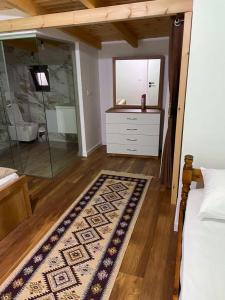 a bedroom with a bed and a mirror and a rug at Shegani House in Lin