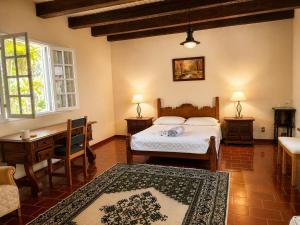 a bedroom with a bed and a desk and a table at Fazenda Vista Soberba in Nova Friburgo
