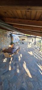 a wooden table and chairs on a stone patio at Home Dimitra in Grammatikiánoi