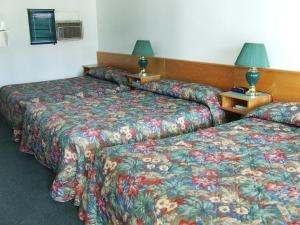 A bed or beds in a room at Ponderosa Motor Inn