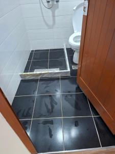 a bathroom with a toilet and a tiled floor at Laboti Quiet Room in Librazhd