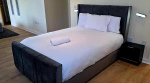 a large bed with a black headboard with a pillow on it at West Beck House Darlington - Penthouse Double En-Suite in Darlington