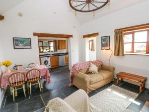 a living room with a couch and a table at Ysgol Hill Cottage in Rosebush