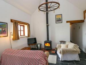a living room with a wood stove in a room at Ysgol Hill Cottage in Rosebush