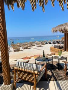 a view of a beach with chairs and tables at Sea't La Vie Villas in Hamallë