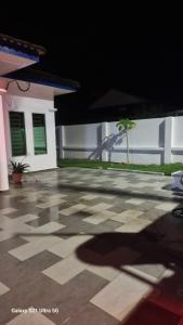 a shadow of a person on a patio at homestay chendorini cherating in Kampong Chendar