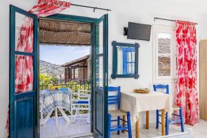 a room with a table and chairs and a window at Stamatis Rooms in Skopelos Town