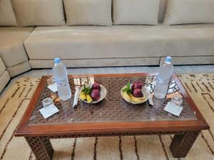 a coffee table with two bowls of fruit and two bottles of water at Villa RAHA villa entière in El Aggada