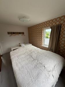 a bedroom with a white bed and a window at Bed en Brood Prunushof in Zelhem
