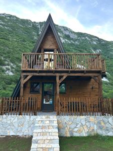 a large wooden cabin with a deck on a mountain at Komarnica Forest Owl 2 in Šavnik
