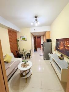 a living room with a couch and a table at Shell Residences Condotel near Mall of Asia - Aiza's Place in Manila