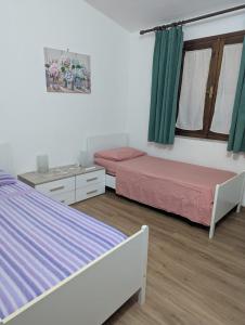 two beds in a room with green curtains at Villa cesar in Costa Paradiso +18 photos