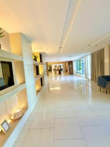 a living room with a large white tile floor at Shell Residences Condotel near Mall of Asia - Aiza's Place in Manila