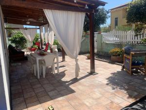 a patio with a white canopy and a table at Casa Maria in Matzaccara