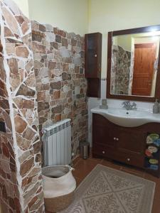 a bathroom with a sink and a stone wall at Casa Maria in Matzaccara