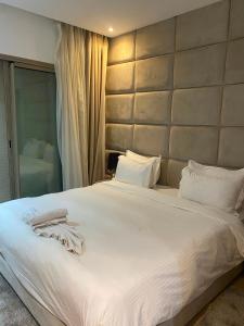 a bedroom with a large white bed with a large headboard at Prestigia Marrakech in Inezgane