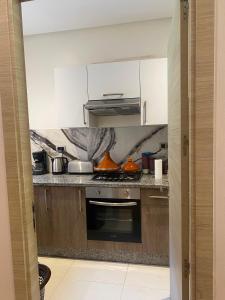 a kitchen with white cabinets and a stove top oven at Prestigia Marrakech in Inezgane