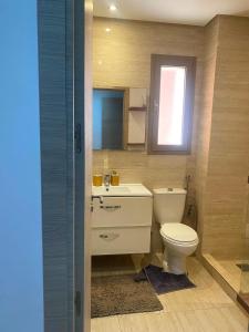 a bathroom with a toilet and a sink and a window at Prestigia Marrakech in Inezgane