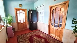 a hallway with two wooden doors and a rug at Sarvan's Khinalig Riverside Montain House in Xınalıq
