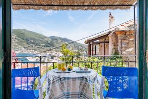 a table and chairs on a balcony with a view at Stamatis Rooms in Skopelos Town