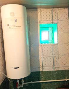 a water heater in a bathroom with a window at Sarvan's Khinalig Riverside Montain House in Xınalıq