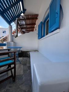 a building with blue windows and a table and chairs at Kapetan Sorokos Studios 2 in Koufonisia