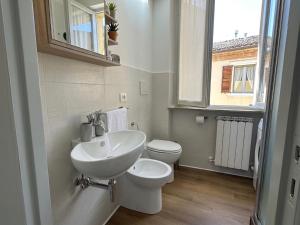 a bathroom with a sink and a toilet and a window at La Piazzetta in Cingoli